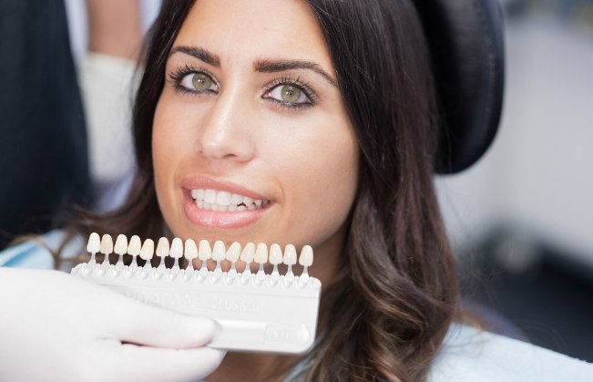 Woman trying on dental veneers from Covington cosmetic dentist