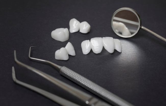 Several metal free dental restorations with dental tools on metal table