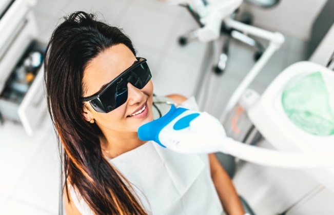 Woman getting professional teeth whitening from cosmetic dentist