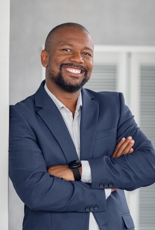 Man in business jacket smiling with dental implants in Covington