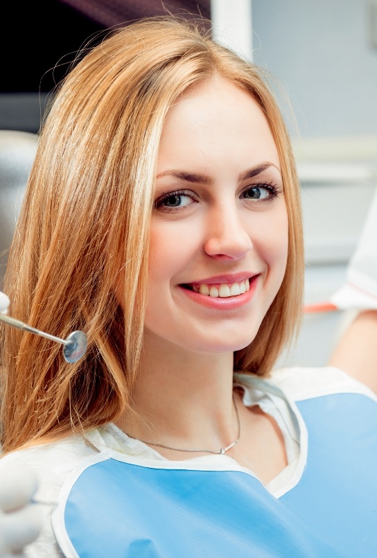 Woman smiling in dental chair at Covington dental office