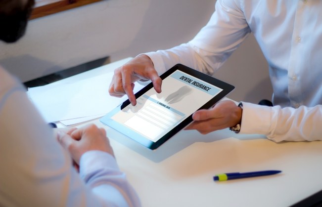 Two people looking at dental insurance form on tablet