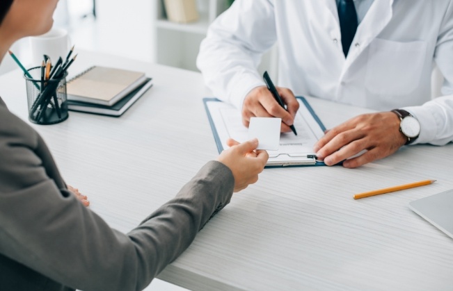 Patient handing a payment card to a dentist