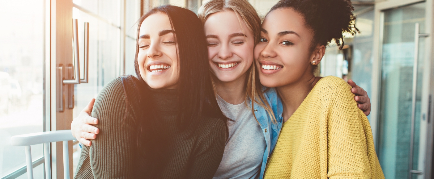 Three young women smiling together