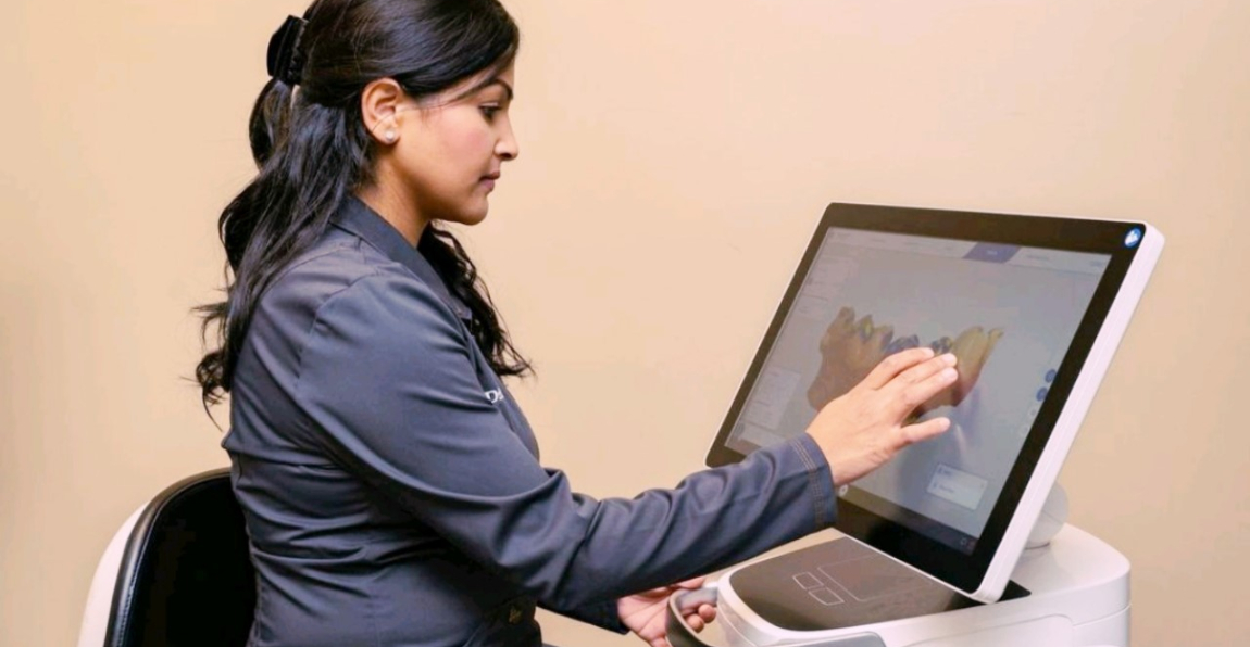 Covington dental team member looking at digital models of teeth on computer screen