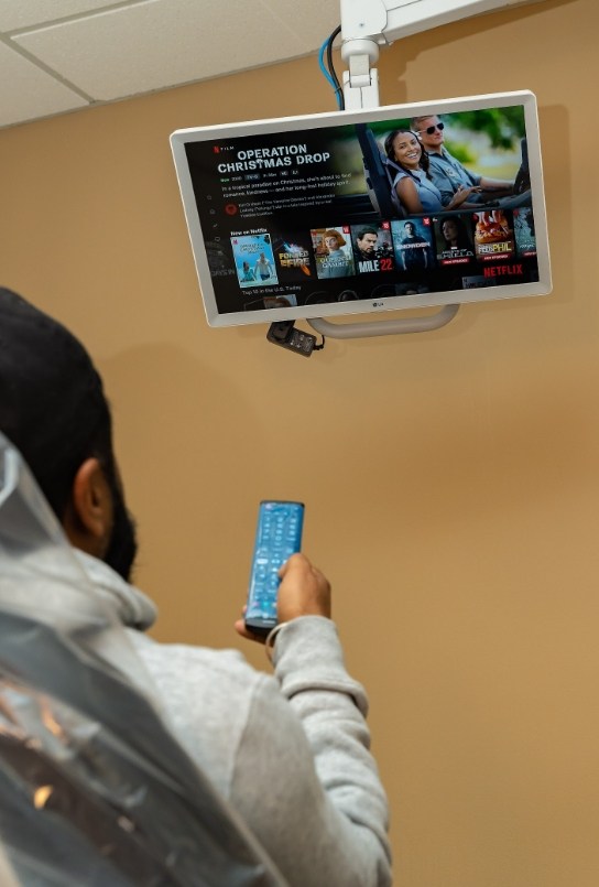 Dental patient using Netflix on T V in Covington dental office