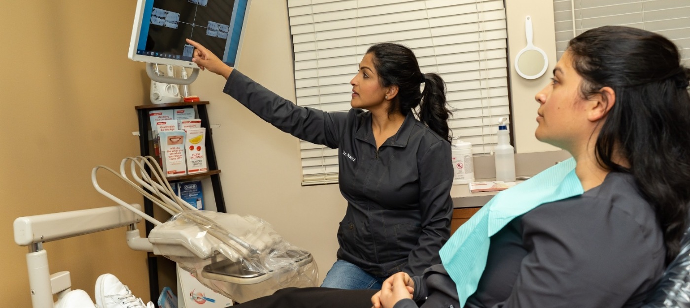 Dentist showing X rays to dental patient before dental services in Covington