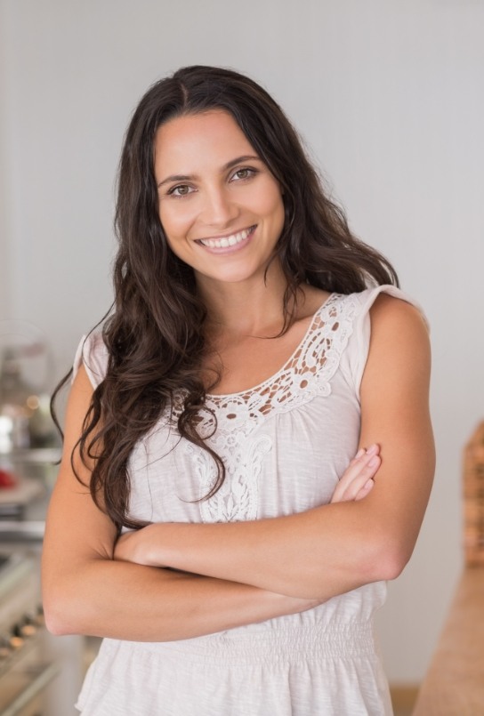 Woman in white blouse smiling after preventive dentistry in Covington