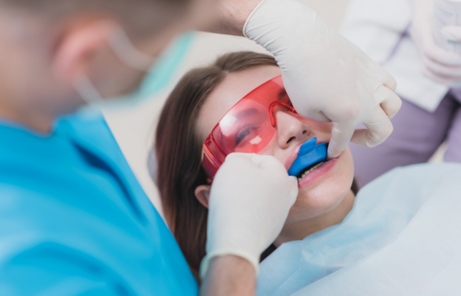 Young woman getting fluoride treatment during preventive dentistry visit