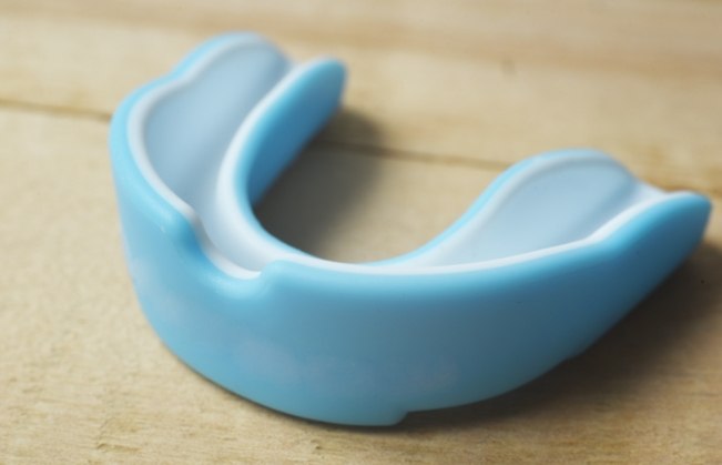 Light blue mouthguard on wood table