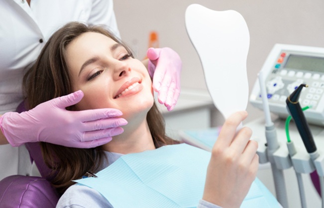 patient smiling in dental mirror  